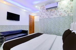 a bedroom with a bed and a flat screen tv at Hotel O Akki Residency in Indirapuram +21 photos