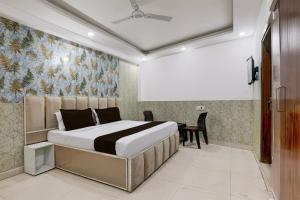 a bedroom with a bed and a table at Hotel O Akki Residency in Indirapuram