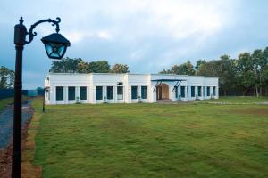 a white building with a street light in front of it at Serene Kabini Wild lodge in Kabini River
