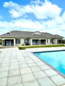 een huis met een zwembad ervoor bij WeMvula Guesthouse in Mtubatuba