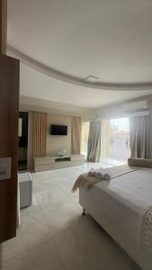 a bedroom with a large bed and a large window at Pousada Vista Encantada Preá in Cruz