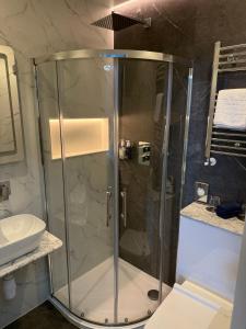 a shower with a glass door in a bathroom at Llandudno Bay Hotel in Llandudno +130 photos