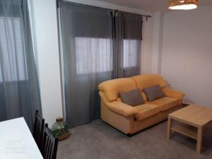 a living room with a yellow couch and a table at Ca L'Esparter in Bocairent