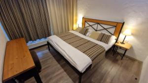 デマノブスカ・ドリーナにあるJasna Chalet - Chopok viewのベッドと木製テーブルが備わるホテルルームです。