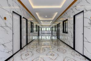 a corridor of a building with marble walls and ailed floor at Hotel O Nilkanth Nivas in Puri
