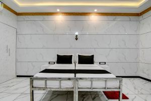 a bedroom with a bed in a white wall at Hotel O Nilkanth Nivas in Puri +33 photos