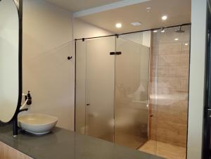 a glass shower in a bathroom with a sink at Hotel Rulay Medellin in Medellín +98 photos