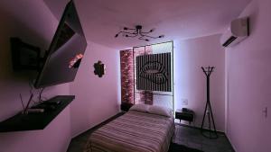 a bedroom with pink walls and a bed with a window at Sabalo's Hausen in Mazatlán
