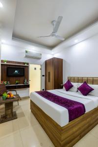 a bedroom with a large bed with purple pillows at Hotel Aura Grand sector 63A Noida I Couple Friendly in Noida