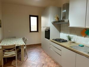 a kitchen with a table and a small kitchen with a table and chairs at Casa D'Amuri in Palma di Montechiaro