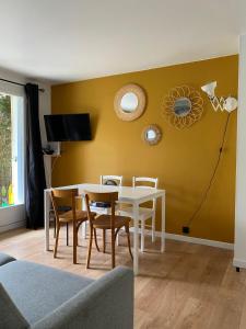 ein Esszimmer mit einem weißen Tisch und Stühlen in der Unterkunft Les Frimousses in Cabourg + 26 Fotos