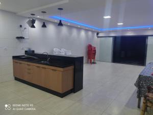 a large room with a black counter and a projection screen at Balihahls in Prudentópolis +16 photos