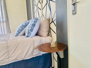 a bed with blue pillows and a wooden table at ZM Rooted Properties in Frankfort