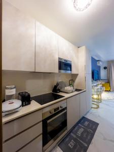 a kitchen with white cabinets and a stove top oven at Luxury Studio Apt at 233 Boulevard Cantonment-Accra in Accra