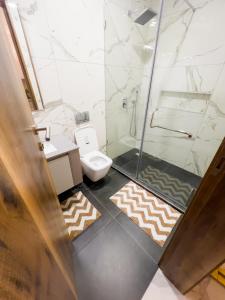 a bathroom with a shower and a toilet and rug at Luxury Studio Apt at 233 Boulevard Cantonment-Accra in Accra
