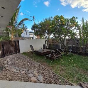 een achtertuin met een picknicktafel en een hek bij Appartement st leu Vill'Alizoé in Entre-Deux