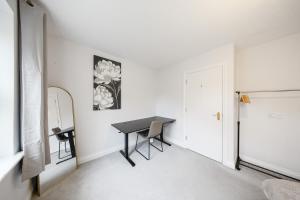 a white room with a table and a mirror at Cozy Two Bedroom House with Driveway Parking & Garden in Chatham +12 photos
