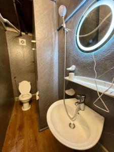 a bathroom with a sink and a mirror and a toilet at Ubuntu Central Stay 57 Hang Be in Hanoi