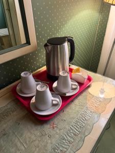 a tray with three cups and a tea pot on a table at Locanda Ruga Rialto in Venice +35 photos