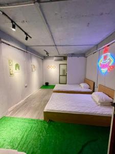 a room with two beds and a neon sign on the wall at Ubuntu Central Stay 57 Hang Be in Hanoi