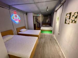 a room with two beds and a neon sign at Ubuntu Central Stay 57 Hang Be in Hanoi +5 photos