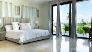 a white bedroom with a bed and a balcony at Ka' Romana Residences in El Soco +281 photos