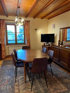 a dining room with a wooden table and chairs at Gîte 6 personnes Chez Gaby in Montgreleix