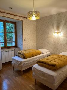 a room with two beds and a chandelier at Gîte 6 personnes Chez Gaby in Montgreleix