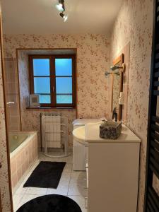 a bathroom with a tub and a sink at Gîte 6 personnes Chez Gaby in Montgreleix