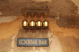 a chandelier hanging from a wall with aatal bar sign at Piedra y Luz in Buendía +23 photos