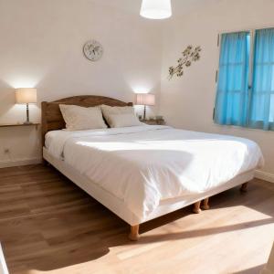 a large bed in a bedroom with a clock on the wall at Domaine de Fayence in Fayence