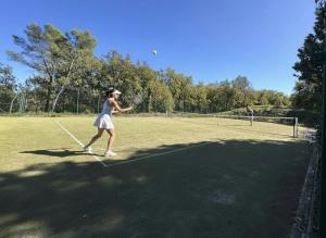 a woman swinging a tennis racket on a tennis court at Domaine de Fayence in Fayence