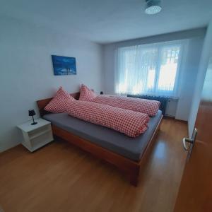 a bedroom with a bed with red and white pillows at Bunderbach in Adelboden