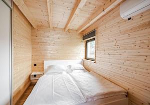 Zimmer mit einem Bett in einer Holzwand in der Unterkunft RESORT SALIXA u Poděbrad in Poděbrady + 7 Fotos