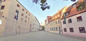 une rue vide dans une ville avec des bâtiments dans l'établissement LUXOMES - Tropical & Streetart Style - Old Town Apartments - Central Ingolstadt, à Ingolstadt