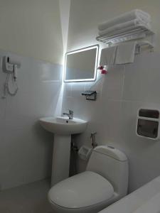 a white bathroom with a toilet and a sink at Casa Thea Cebu in Talisay +5 photos