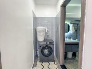 a bathroom with a washing machine and a sink at Getaways homes in Nairobi