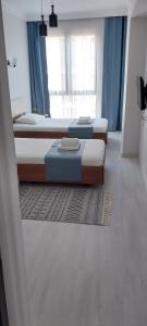 two twin beds in a room with blue curtains at Your home in the heart of Batumi, sea in 8th minute in Batumi