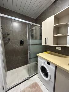 a bathroom with a shower and a washing machine at Your home in the heart of Batumi, sea in 8th minute in Batumi