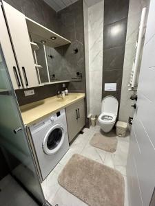 a bathroom with a washing machine and a toilet at Your home in the heart of Batumi, sea in 8th minute in Batumi +30 photos