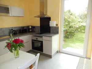 a kitchen with a table with a vase of flowers on it at Logement indépendant dans cité médiévale in La Charité-sur-Loire +11 photos