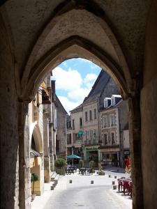 an archway in a city with tables and chairs at Logement indépendant dans cité médiévale in La Charité-sur-Loire