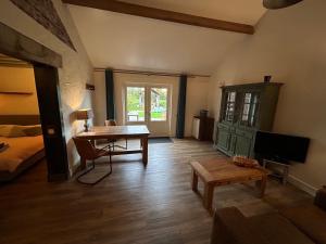 a living room with a table and a bed at Hoeve Delshorst in Heibloem