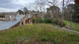 Ein altes Haus auf einem Grasfeld in der Unterkunft Ecos Casas de Montaña in Sierra de la Ventana