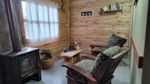 ein Wohnzimmer mit einem Kamin und einem Herd in der Unterkunft Ecos Casas de Montaña in Sierra de la Ventana