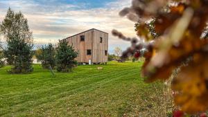 eine hölzerne Scheune auf einem Feld mit grünem Gras in der Unterkunft RESORT SALIXA u Poděbrad in Poděbrady