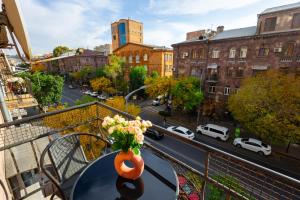 a vase of flowers sitting on a table on a balcony at 1 bedroom Modern, Sunny apartment in Amiryan street AM104 in Yerevan