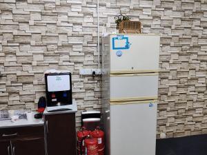 a kitchen with a refrigerator next to a brick wall at Vintage Inn Jonker Walk Melaka in Melaka