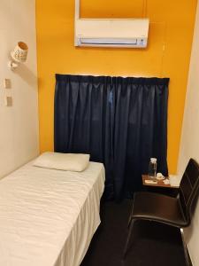 a room with two beds and a black curtain at Vintage Inn Jonker Walk Melaka in Melaka