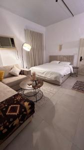 ein Wohnzimmer mit einem Bett und einer Couch in der Unterkunft شقة حي البوادي in Dschidda